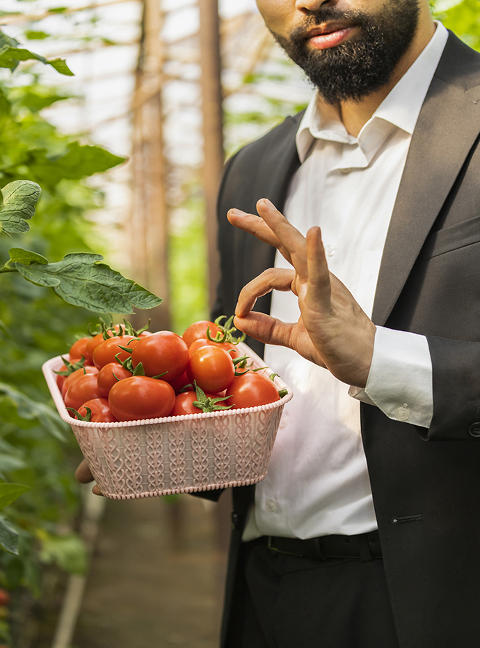 a man holding a basket of tomatoes